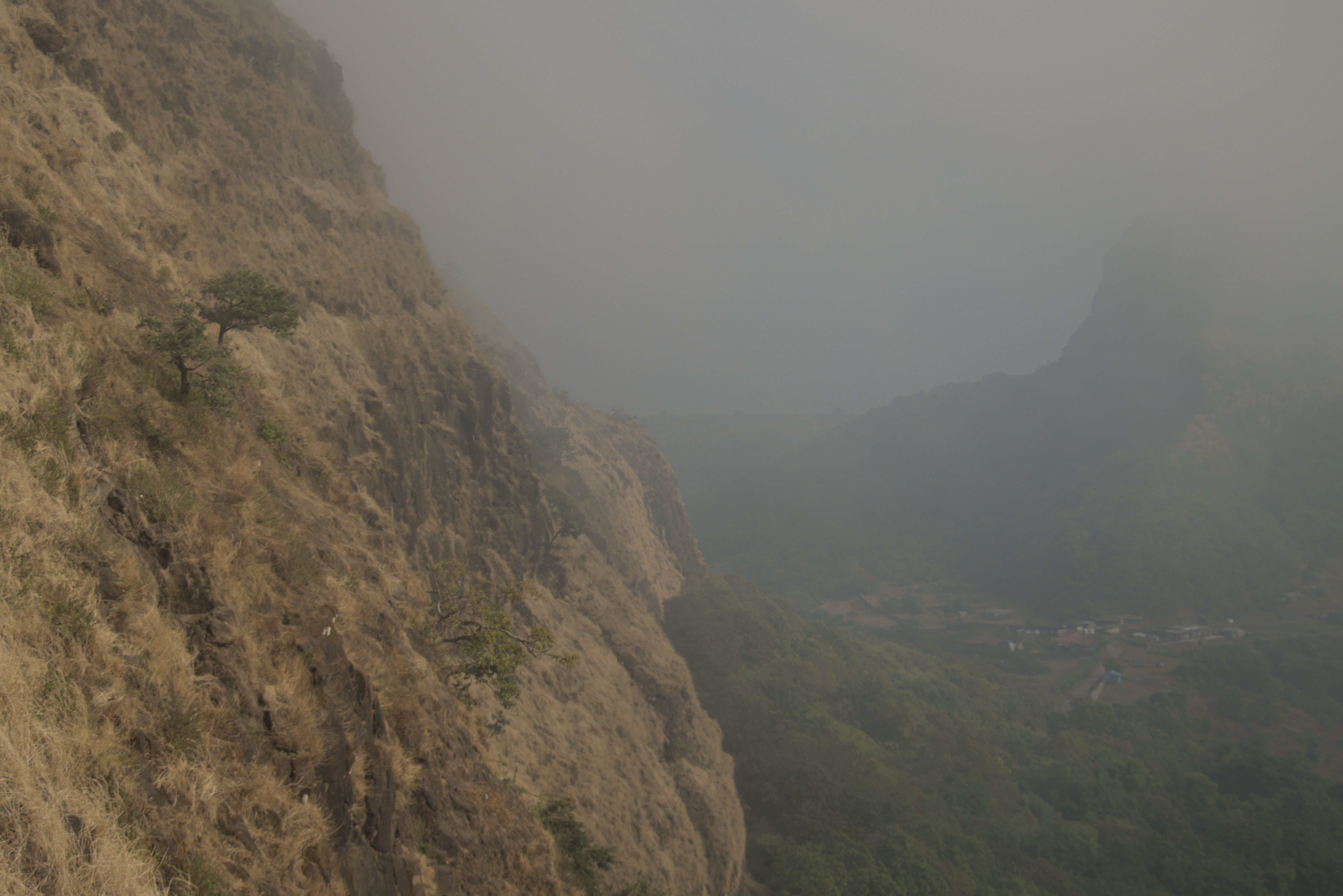 Looking down into the valley with Visapur Fort obscured by the fog in the top right.